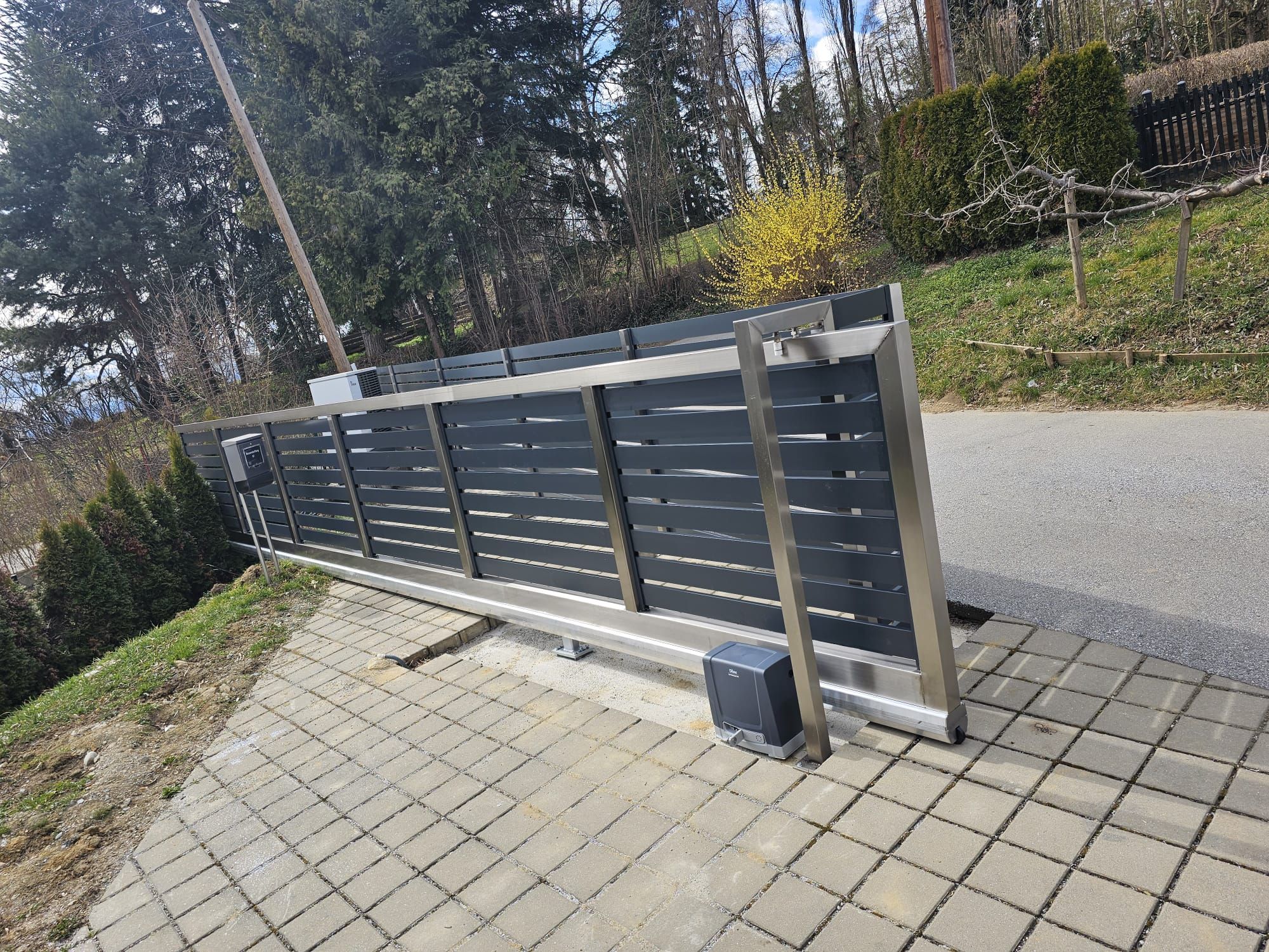 Automatisches anthrazitfarbenes Einfahrtstor mit elektrischem Antrieb und Fernbedienung