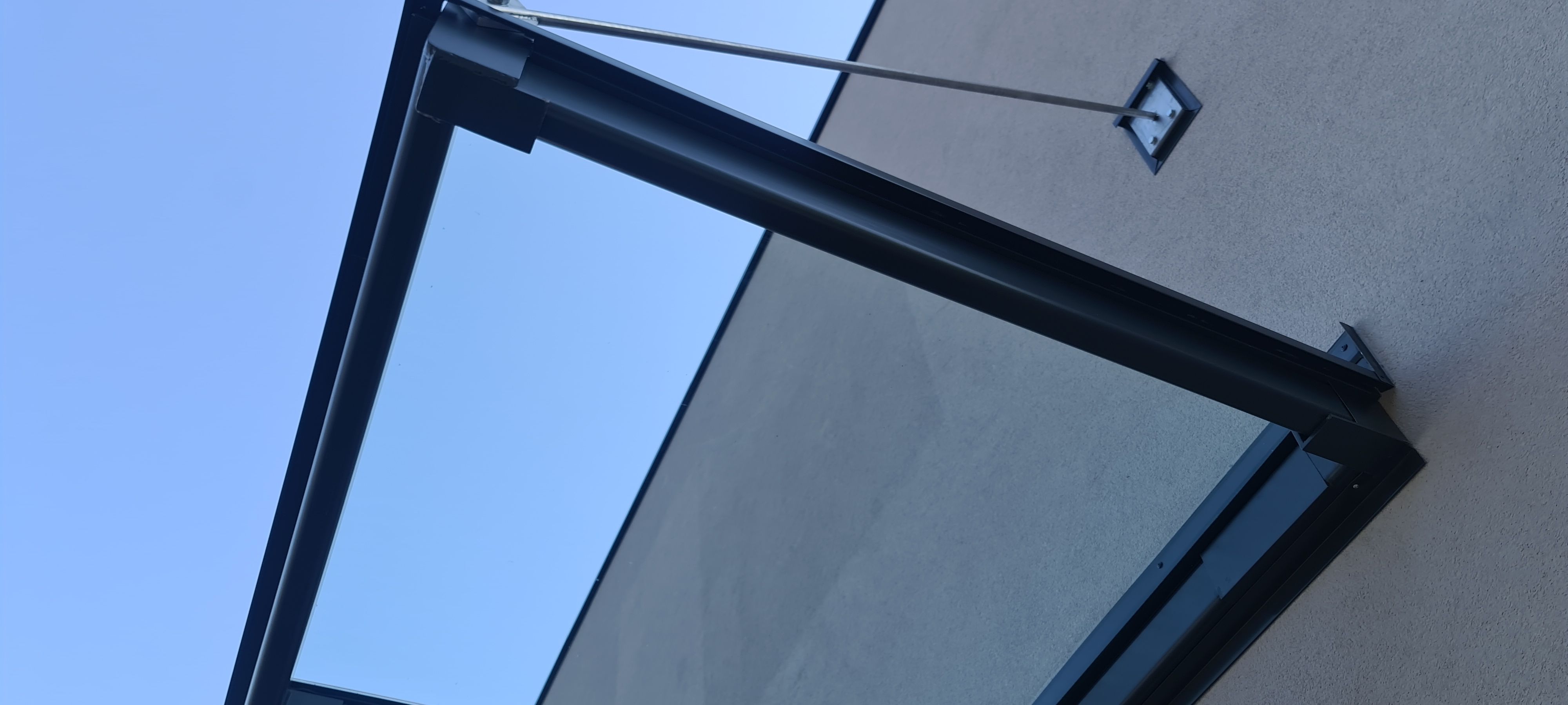 Elegante Glasüberdachung mit anthrazitfarbener Stahlkonstruktion und transparenter Glaseindeckung